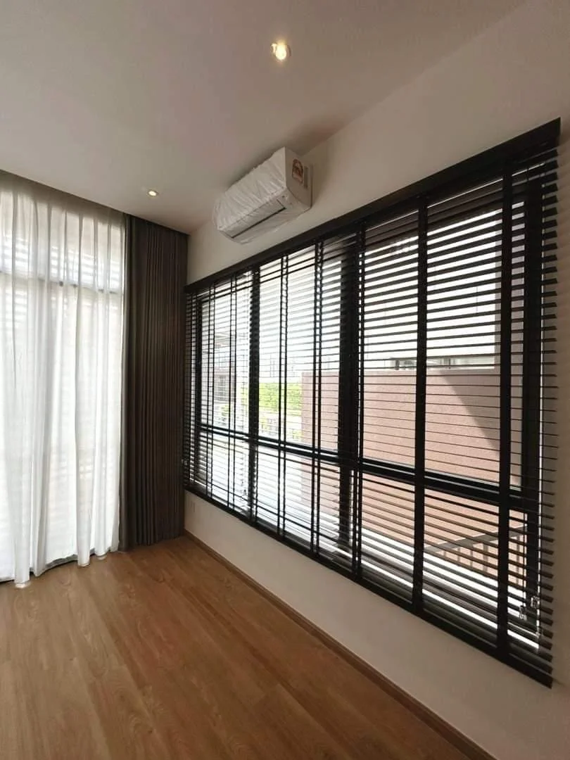Dark Venetian blinds with sheer curtains